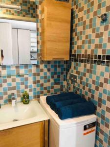 a bathroom with a toilet with a blue cushion on it at Week-end Porte de Clichy in Clichy