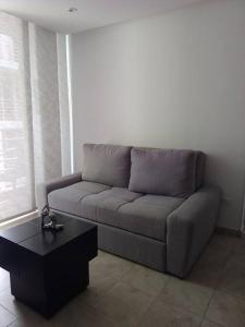a living room with a couch and a coffee table at Mejor ubicación de la ciudad in Ibagué +1 photo