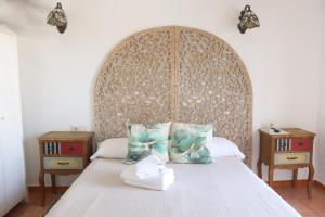 sypialnia z łóżkiem z dużym drewnianym zagłówkiem w obiekcie Hotel Casa Día y Noche w mieście Calpe
