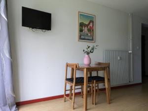 a room with a table and a tv on a wall at Entre mer et montagne in Souraïde