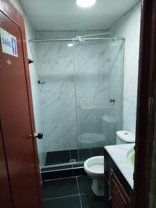a bathroom with a glass shower and a toilet at Hostal la 18 in Pereira +6 photos