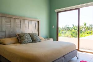 une chambre avec un grand lit avec une grande fenêtre dans l'établissement Modern House 3 Bedrooms & Pool Acapulco, à Acapulco 45 autres photos