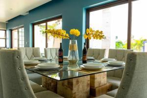 une salle à manger avec une table avec des chaises et des fleurs dans l'établissement Modern House 3 Bedrooms & Pool Acapulco, à Acapulco