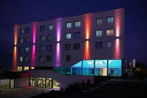 a large building with a clock on the side of it at Mercure Bale Mulhouse Aeroport in Blotzheim