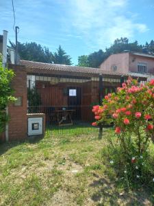 a backyard of a house with a fence and flowers at A Pura Vida in Santa Teresita