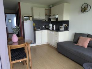 a kitchen and a living room with a couch and a table at Entre mer et montagne in Souraïde