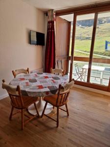 a table and chairs in a room with a window at Appartement aux pieds des pistes - Apollo Le Corbier in Villarembert