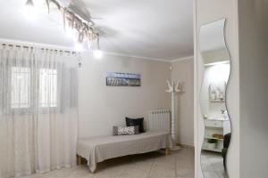 Habitación blanca con espejo y cama en Dimora Algano Apartment, en Fasano
