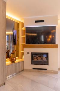 a living room with a fireplace and a tv at BALCON DE BENASQUE S Radiante Cama King Alta Gama Parking Incluido in Benasque