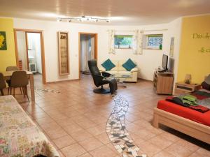 a living room with a couch and a chair at Appartement Am Goldberg in Goldbach