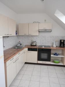 a kitchen with white cabinets and a black microwave at Appartement Am Goldberg in Goldbach