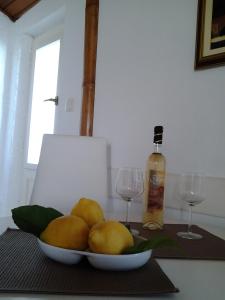 a bowl of pears on a table with two wine glasses at Apartments Mare in Hvar
