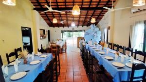 a dining room with long tables with blue tablecloths at Santa Maria Hotel in Santa María