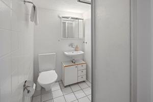 a white bathroom with a toilet and a sink at ARISER - Zug Unique Apartment in Historic 15th Century Building in Zug