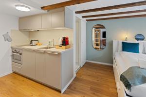 a kitchen and a bedroom with a bed and a sink at ARISER - Zug Unique Apartment in Historic 15th Century Building in Zug
