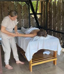a woman standing next to a woman laying on a bed at La Mar de Bien Tayrona in Buritaca