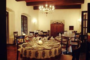 a dining room with tables and chairs and a chandelier at Hotel Hacienda Los Laureles in Oaxaca City