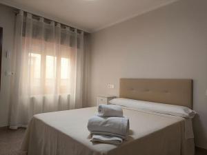 a white bedroom with a bed with towels on it at Casa Parador De Santa María in Villarrobledo