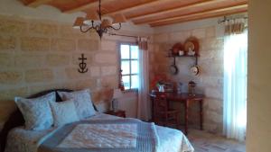 a bedroom with a bed and a table and a window at Le Mazet De Jean in Le Cailar