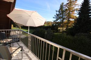 patio ze stołem i parasolem na balkonie w obiekcie NATURBLICK Apartments 3 Moderne Ferienwohnung mit Balkon w mieście Grebenhain +2 zdjęcia