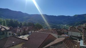 a rainbow over the roofs of a town with mountains at Inima apartments in Metsovo +2 photos