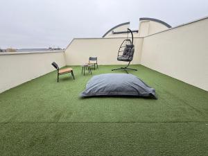 a patio with green grass and chairs on a building at Appartement Cosy Cergy Le Haut Gare in Cergy