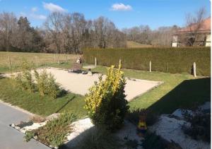 a garden with a bench and a bush with yellow flowers at maison rue de la plage in Lanobre +5 photos