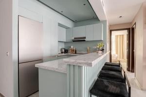a kitchen with a counter with stools in it at The Ocean Glimpse - 2 BR Comfort & Sea View in Tangier
