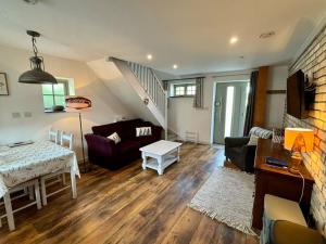 a living room with a couch and a table at Little Bream - pretty cosy cottage, sea views, walk to the beach in Mawnan Smith +34 photos
