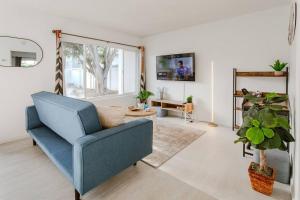 a living room with a blue chair and a plant at King Suite - Steps to Beach & Close to Pier in Oceanside