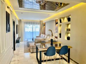 a living room with a table and chairs and a couch at Golden Sand Apartment - Terrace & OceanView 2BD in Tangier