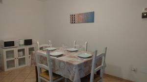 ガルドーネ・リヴィエラにあるAGORA' Homeのダイニングルーム(椅子、白いテーブルクロス付)