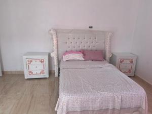 - une chambre avec un lit blanc et 2 tables de chevet dans l'établissement Casa las Américas, à La Alianza