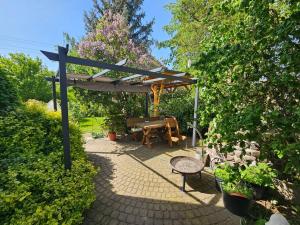 a picnic table and bench under a wooden pergola at FeWo Wittig am Kulturbahnhof 2 in Leisnig