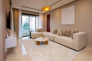 una sala de estar con un sofá y una mesa en Prestigia Gem Spacious 3BR Flat in Hay Riad, en Rabat