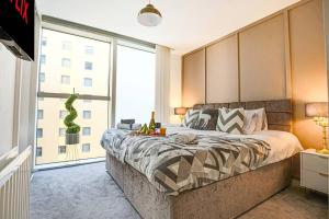 a bedroom with a large bed and a large window at City Centre Apartment with Free Parking, Self Check-In, Sky TV and Fast WiFi by Yoko Property in Milton Keynes