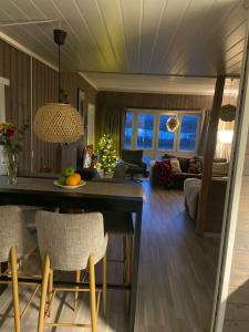 une cuisine et un salon avec une table et des chaises dans l'établissement Cosy cabin in North-Norway, Nearby Senja., à Sorreisa