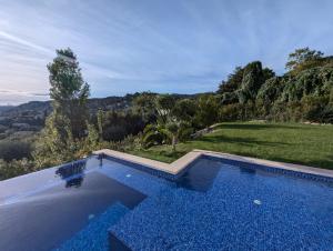 une piscine avec vue sur une colline dans l'établissement Villa Romarin St Paul de Vence, à Saint-Paul-de-Vence