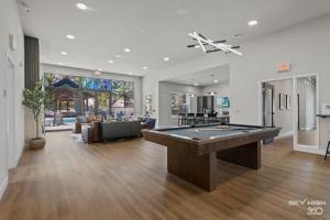 a large living room with a pool table in it at Trails End Here, Pool, King Beds, Gym, Lux Apt in Rogers