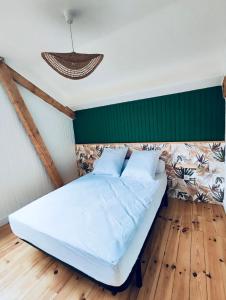a bed in a room with a green wall at Appartement Chalet Cozy au pied des pistes! in Saint-Pierre-dels-Forcats
