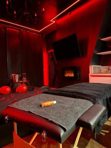 a red room with a bed and a fireplace at Love Room, L'interdit in Rouen +3 photos