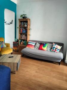 ein Wohnzimmer mit einem Sofa und bunten Kissen in der Unterkunft Linda Habitación en Centro Histórico en Ciudad de Mexico in Mexiko-Stadt
