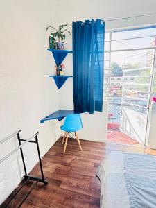 ein Schlafzimmer mit einem blauen Schreibtisch und einem blauen Stuhl in der Unterkunft Linda Habitación en Centro Histórico en Ciudad de Mexico in Mexiko-Stadt