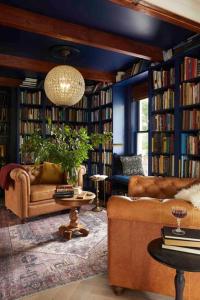 a living room with a couch and some books at The Brick House Mansion in downtown Livingston in Livingston