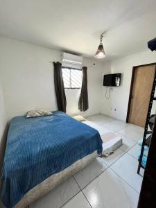 ein Schlafzimmer mit einem blauen Bett und einem gefliesten Boden in der Unterkunft Lugar encantador! in Jacumã + 8 Fotos
