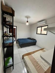ein Schlafzimmer mit einem Bett in der Zimmerecke in der Unterkunft Lugar encantador! in Jacumã