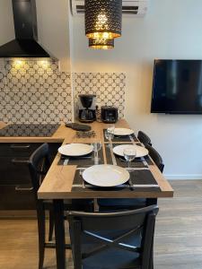 a wooden table with chairs and plates on it at Marianne 3 in Bergerac +15 photos