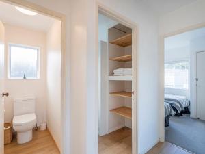 a bathroom with a toilet and a bed in a room at Retreat by the Beach - Pauanui Holiday Home in Pauanui +19 photos