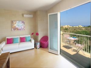 a living room with a couch and a balcony at GozoWindmill Apartments in Qala +37 photos