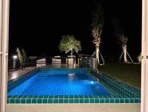 a swimming pool in the middle of a yard at night at Cape House in Ban Bang Kaeo